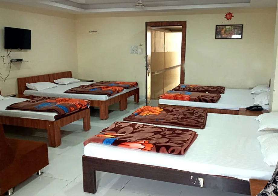 Seven-bed dormitory hall with blankets and TV at Narasinha Mehta Dham Girnar