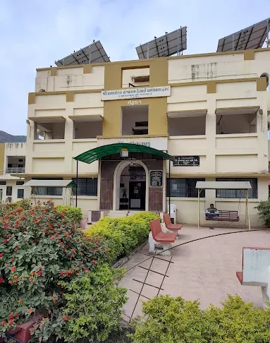 Entrance of Narasinha Mehta Dham dharamshala with garden and rooftop solar panels