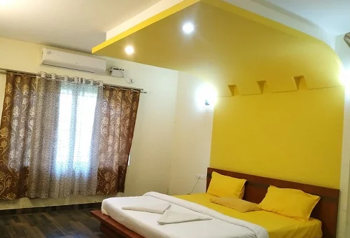 Premium AC room with large bed and window at Narasinha Mehta Dham Girnar